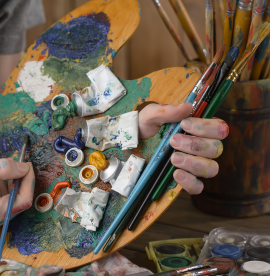 female-artist-hands-with-paint-brushes