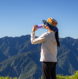 hiking-woman-drink-water-stand-top-mountain