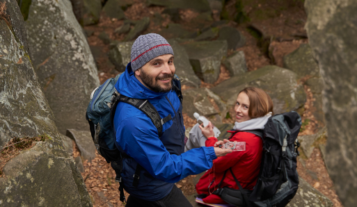 cheerful-man-using-compass-during-rest-stop-with